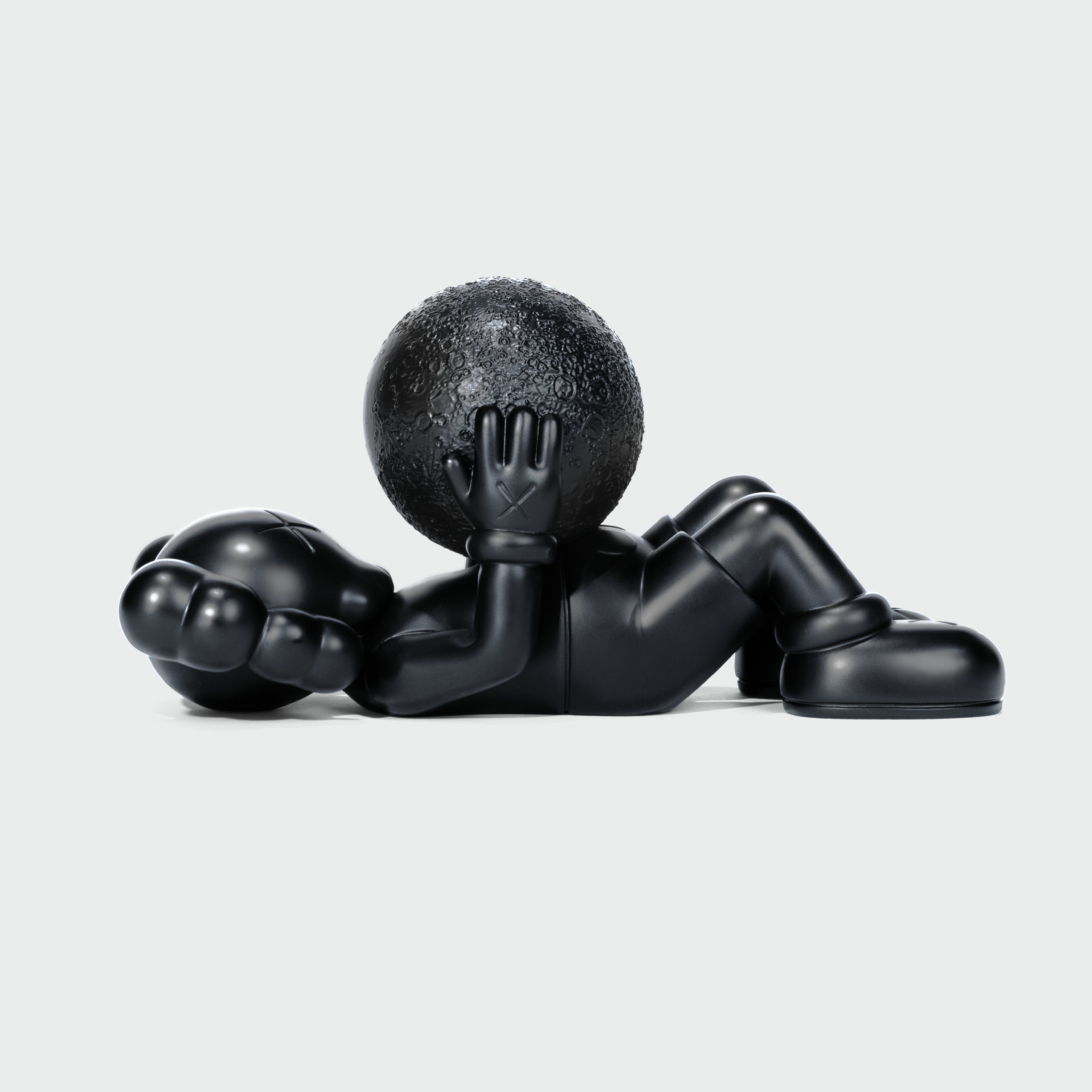 KAWS Calm Night Bronze Sculpture lying down. Side view showing solid bronze material. Includes wooden box and signed COA. Verified authentic by Art Trader.