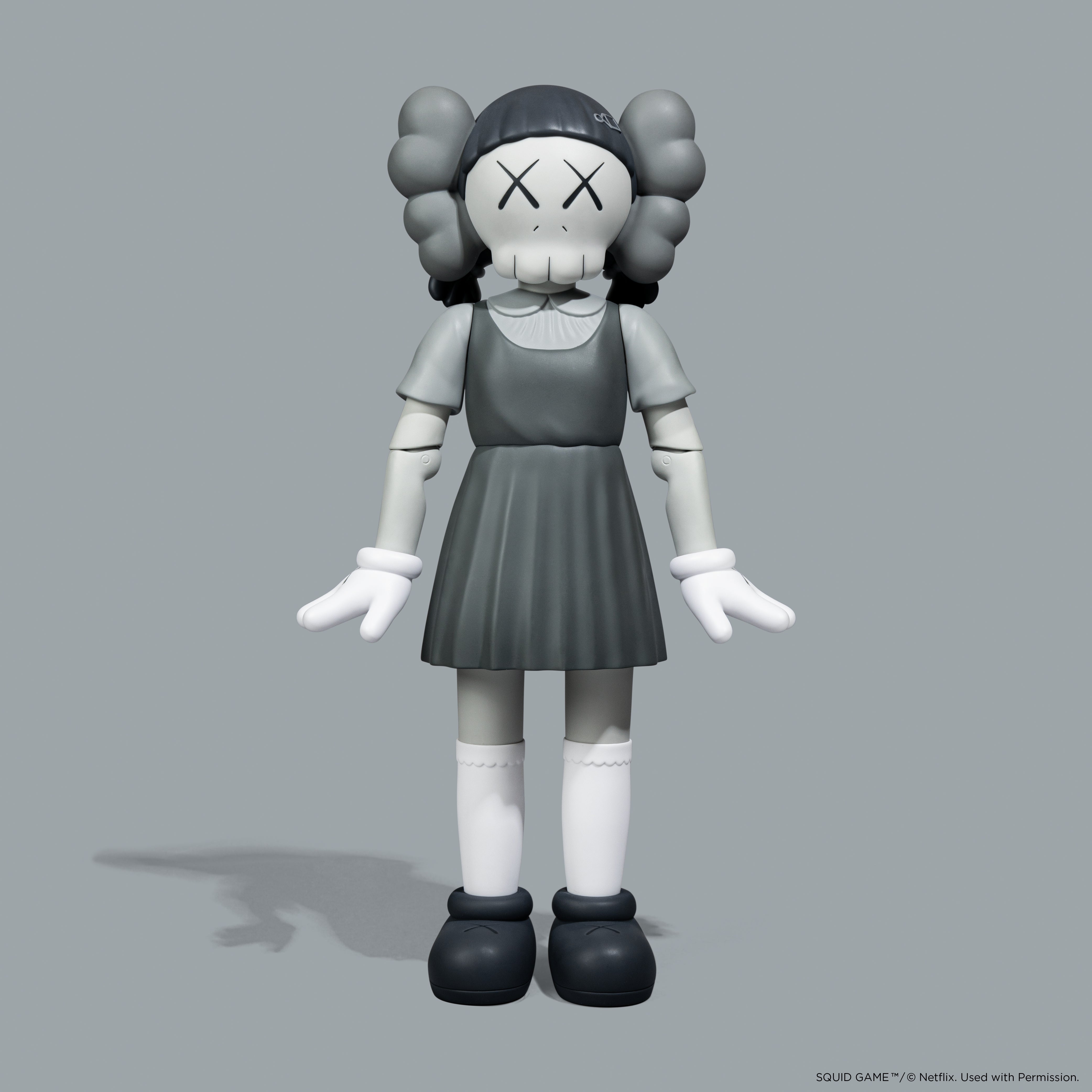 KAWS Squid Game Young-Hee Monotone Grey Vinyl Figure. Minimalist art toy with NFC authentication. Verified authentic by Art Trader.